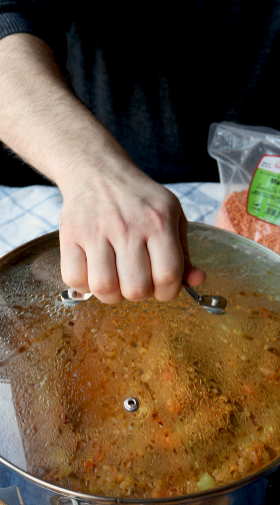 To make this creamy red lentil soup, begin by sautéing onions and minced garlic in oil. Then add carrots and seasonings. Cook for a few minutes, then add tomato paste, red lentils, and water. Bring to a boil, then cover and cook on super low for 30 minutes, or until lentils and carrots are soft. Blend until smooth, then add heavy cream. Add more heavy cream if a more soupy consistency is desired. Top with red pepper flakes and cilantro and enjoy!